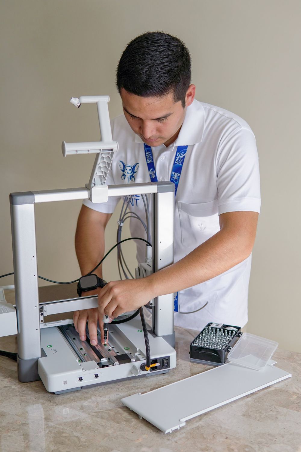Técnico de Space Print dando mantenimiento a una impresora 3D