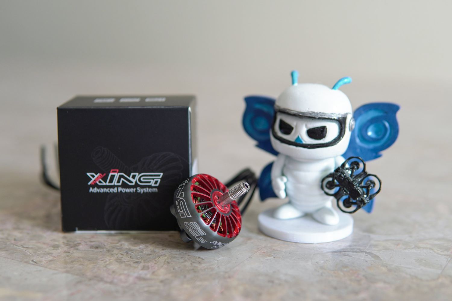 Motor iFlight XING junto a la figura de la mascota