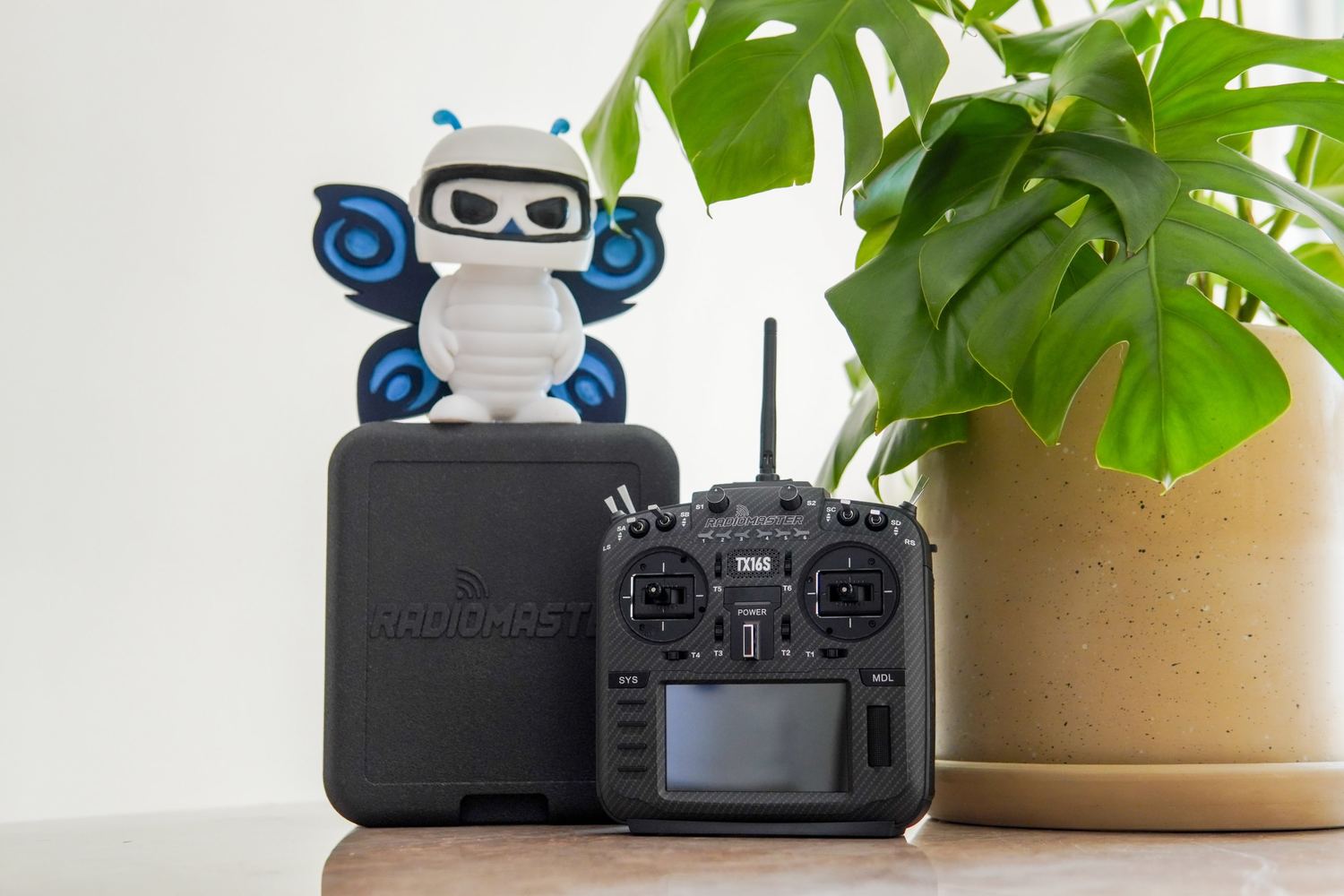 Radio RadioMaster TX16S junto a la figura de la mascota de Space Print